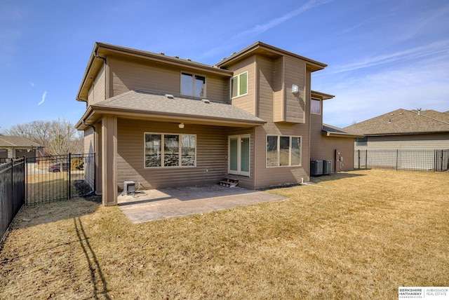 rear view of house with visible vents, a fenced backyard, a yard, roof with shingles, and a patio area