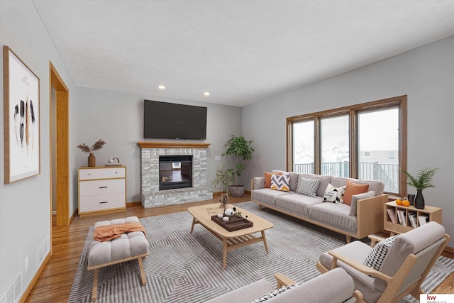 living room with a textured ceiling and light wood-type flooring