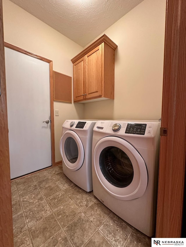 laundry room with separate washer and dryer, cabinets, and a textured ceiling