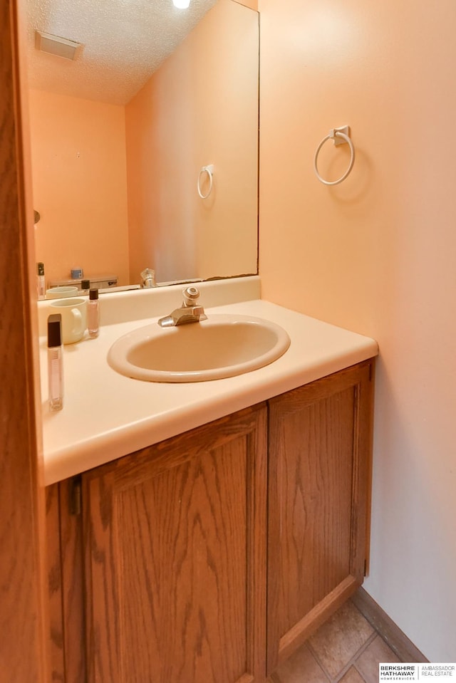 bathroom featuring vanity, tile patterned floors, and a textured ceiling