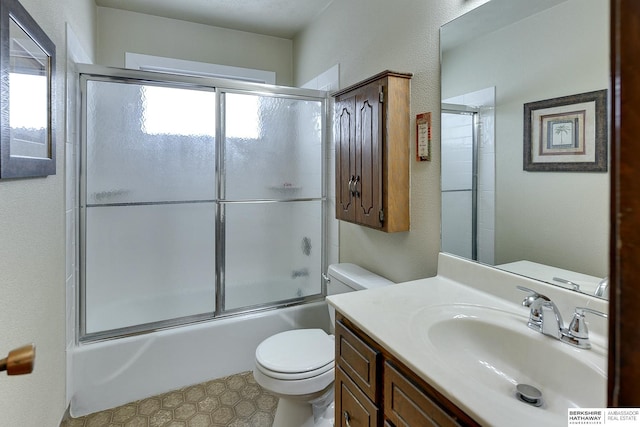 full bathroom with combined bath / shower with glass door, vanity, and toilet