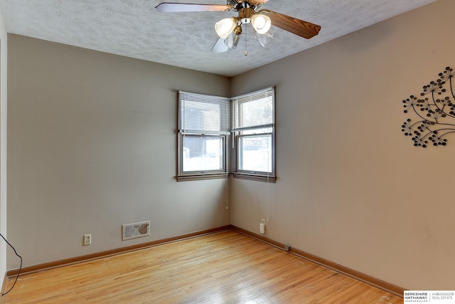 spare room with light hardwood / wood-style floors, ceiling fan, and a textured ceiling