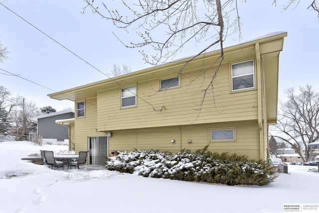 view of snow covered back of property