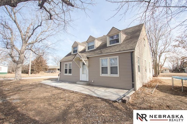 new england style home featuring a patio and a trampoline