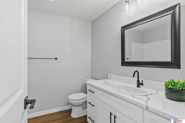 bathroom featuring vanity, hardwood / wood-style flooring, and toilet