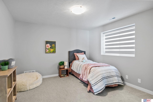 carpeted bedroom featuring a textured ceiling