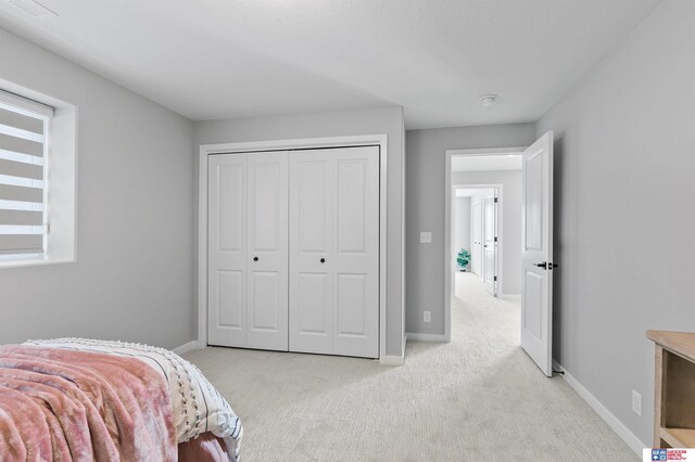 bedroom with a closet and light carpet