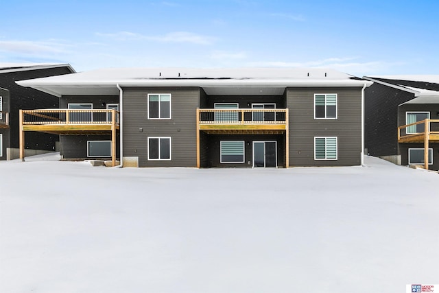 view of snow covered back of property