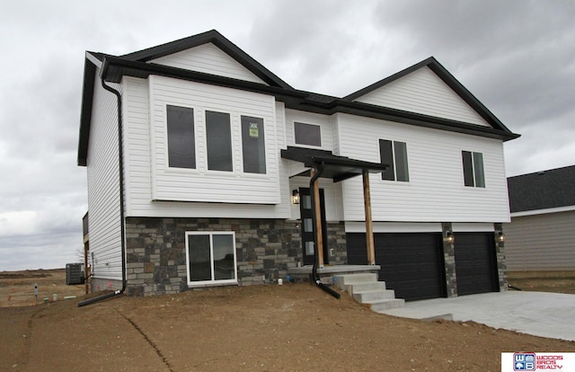 view of front of property with a garage and central AC