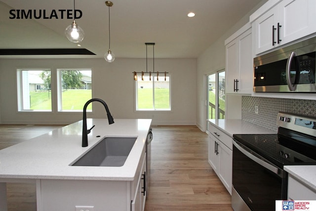 kitchen with white cabinetry, hanging light fixtures, stainless steel appliances, and an island with sink