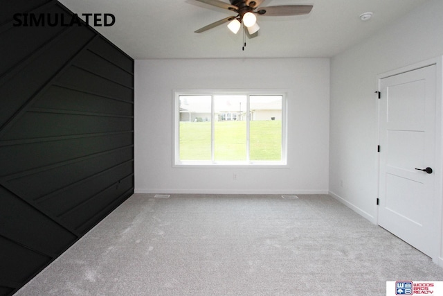 carpeted spare room featuring ceiling fan