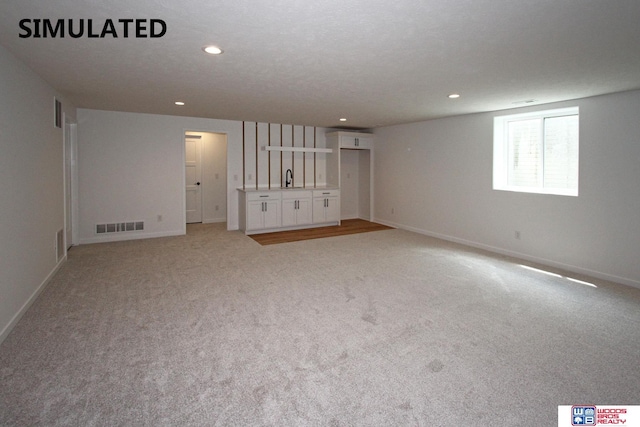 interior space featuring light colored carpet and sink