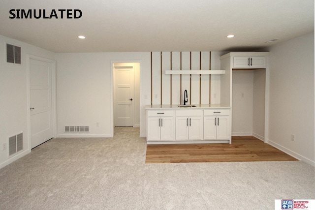 interior space featuring sink and light colored carpet