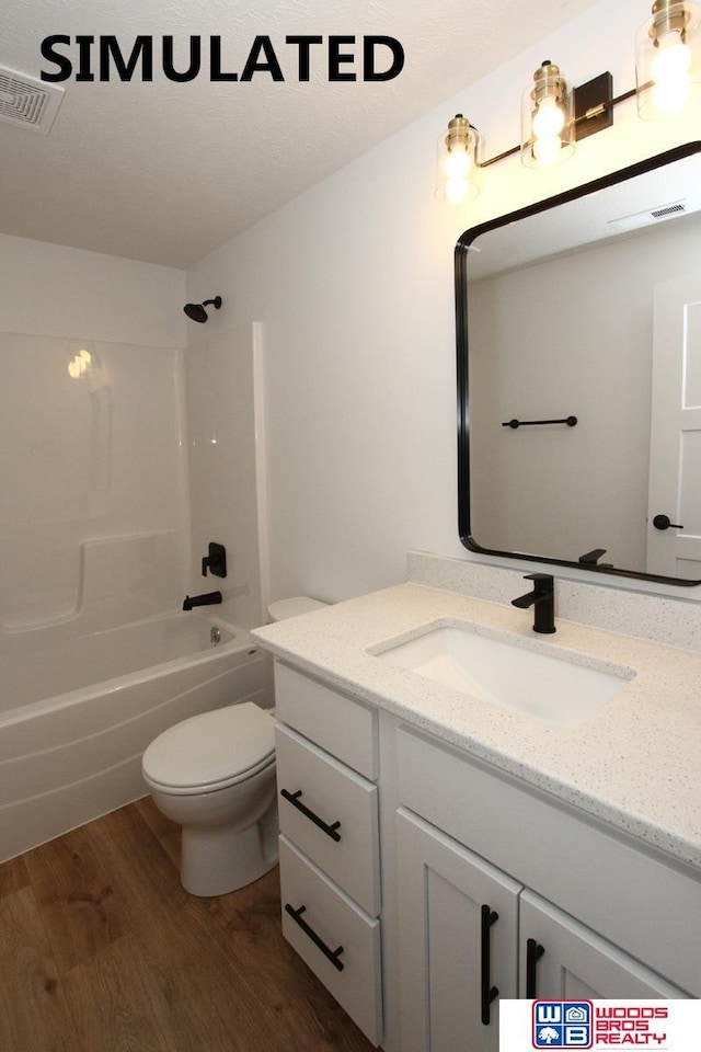 full bathroom with toilet, hardwood / wood-style floors, vanity, and shower / bathing tub combination