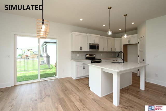 kitchen with hanging light fixtures, white cabinetry, appliances with stainless steel finishes, and sink