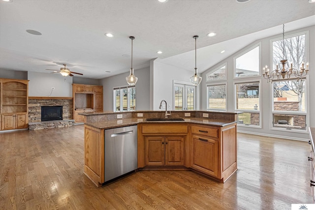 kitchen with sink, dishwasher, a kitchen island with sink, and hanging light fixtures