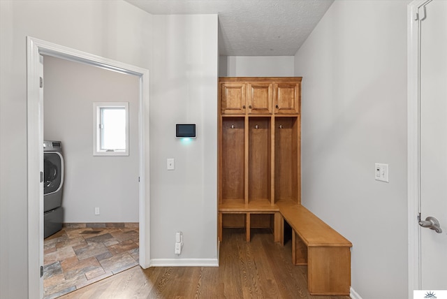 mudroom with wood-type flooring, washer / dryer, and a textured ceiling