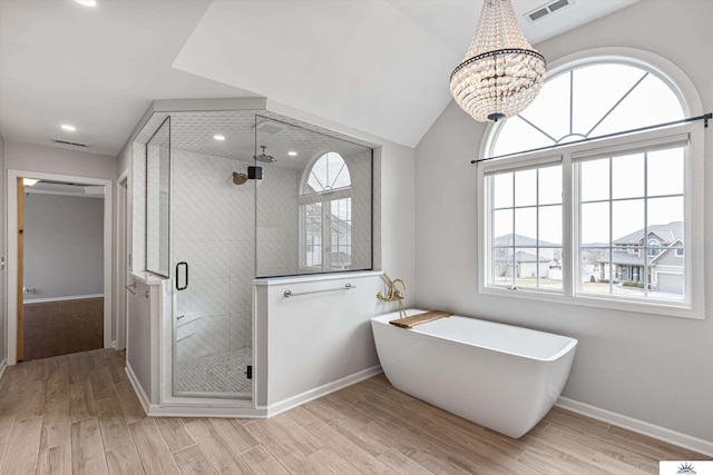 bathroom with independent shower and bath, vaulted ceiling, and hardwood / wood-style floors