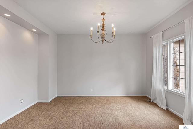 empty room with carpet floors and a chandelier