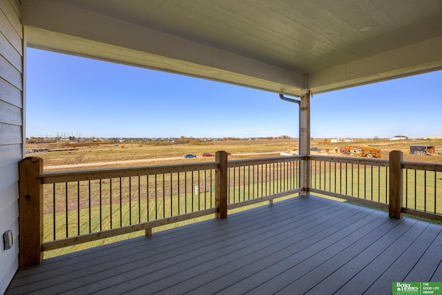 wooden deck featuring a lawn and a rural view