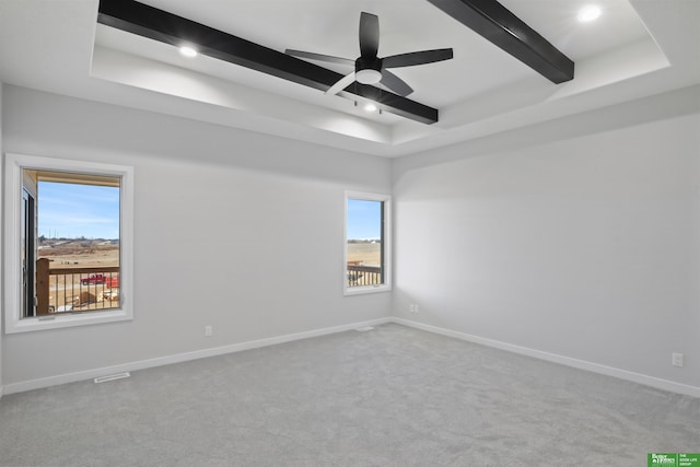 spare room featuring light carpet, ceiling fan, and beamed ceiling