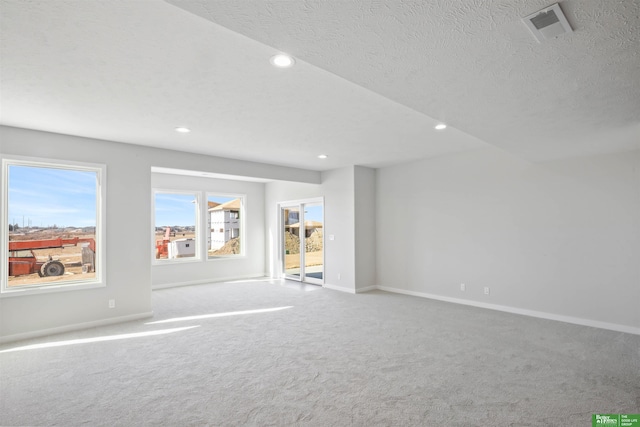 carpeted empty room with a textured ceiling