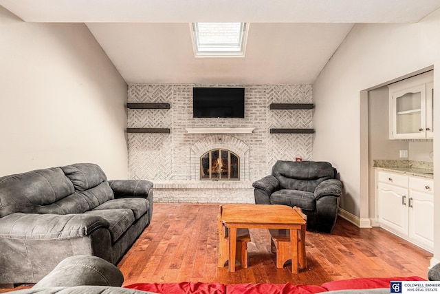 living room with lofted ceiling, a fireplace, and light hardwood / wood-style floors