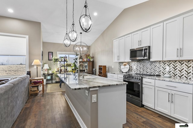 kitchen with sink, white cabinetry, hanging light fixtures, range with electric cooktop, and a center island with sink