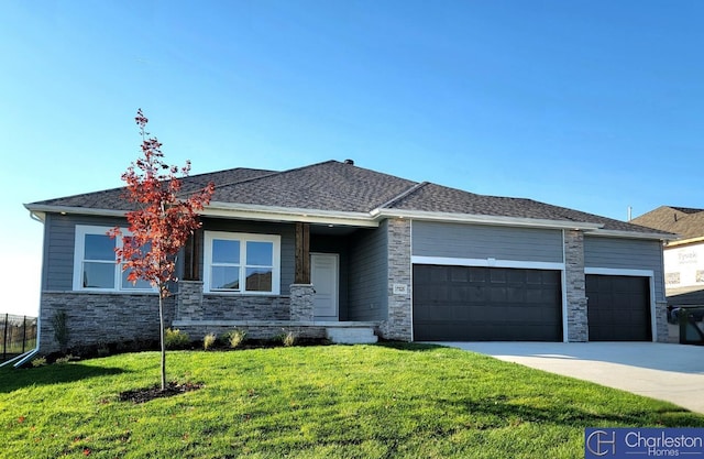 prairie-style home with a garage and a front lawn