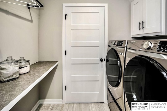 laundry area with light wood-style floors, cabinet space, independent washer and dryer, and baseboards