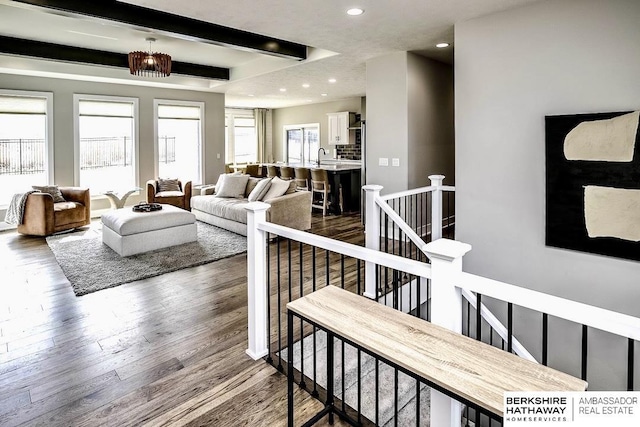 living room with a tray ceiling, sink, and hardwood / wood-style flooring