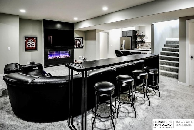 bar featuring light carpet, stainless steel fridge with ice dispenser, and tasteful backsplash