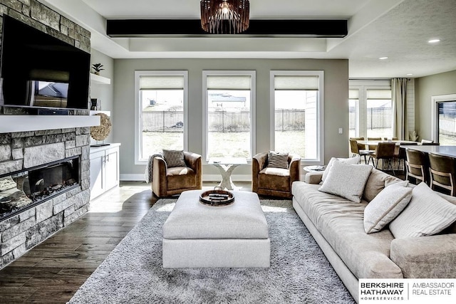 living room with beamed ceiling, dark wood-type flooring, and a fireplace