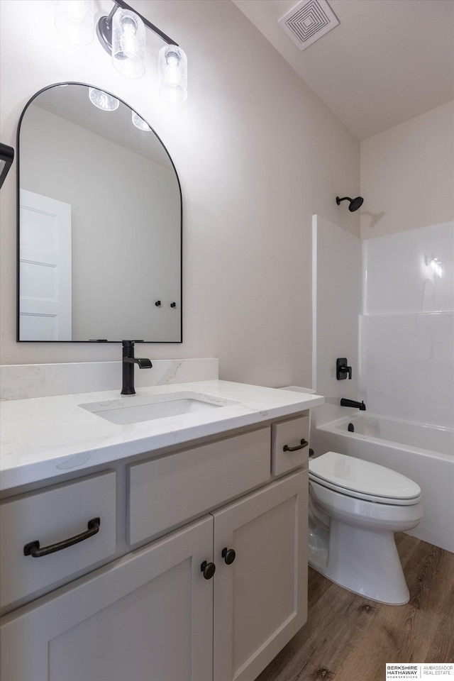 full bathroom featuring vanity, hardwood / wood-style floors, bathtub / shower combination, and toilet