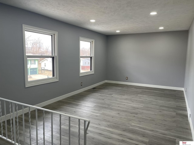 spare room with hardwood / wood-style flooring and a textured ceiling