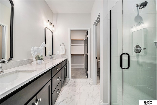 bathroom featuring vanity, a shower with door, and toilet