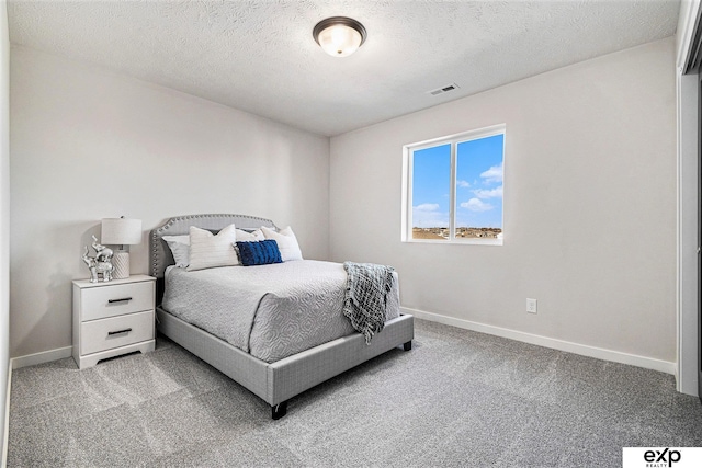 bedroom with carpet and a textured ceiling