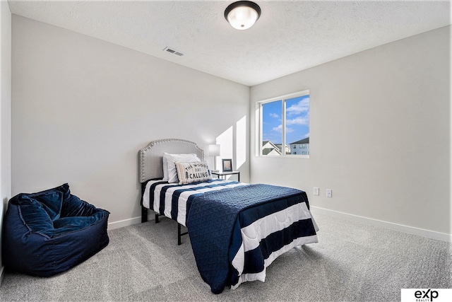 bedroom featuring carpet and a textured ceiling