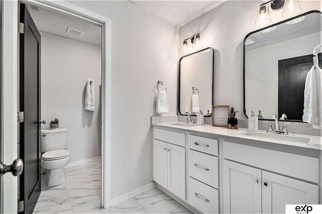 bathroom with vanity, a textured ceiling, and toilet