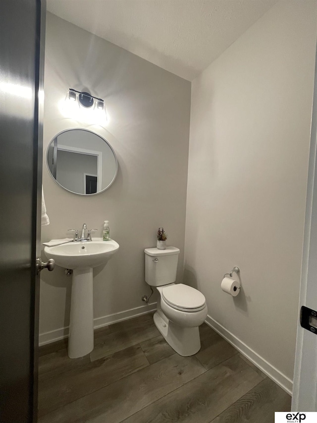 bathroom with wood-type flooring and toilet