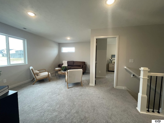 living area with light colored carpet and a textured ceiling