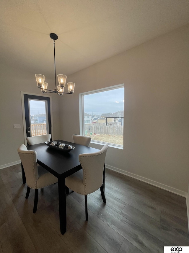 dining area with dark hardwood / wood-style flooring and a chandelier