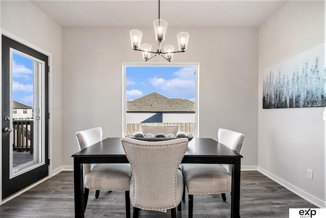 dining area with dark hardwood / wood-style flooring and a notable chandelier