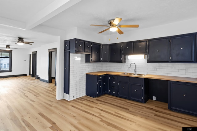 kitchen featuring tasteful backsplash, wood counters, light hardwood / wood-style floors, and sink