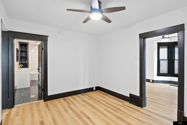 spare room featuring wood-type flooring and ceiling fan