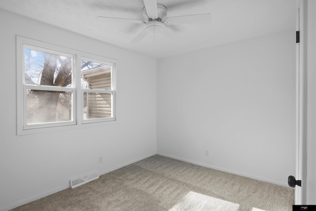 carpeted spare room with ceiling fan