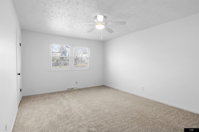 carpeted spare room with ceiling fan and a textured ceiling