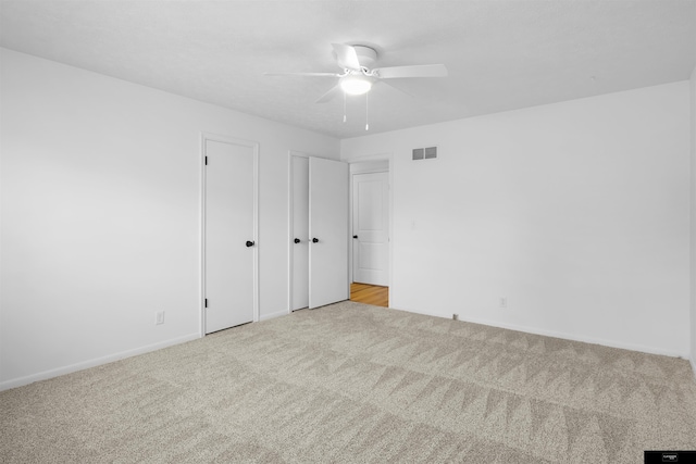 unfurnished bedroom featuring light carpet and ceiling fan