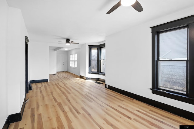 empty room with ceiling fan and light wood-type flooring