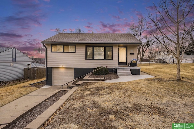 view of front of property with a yard and a garage